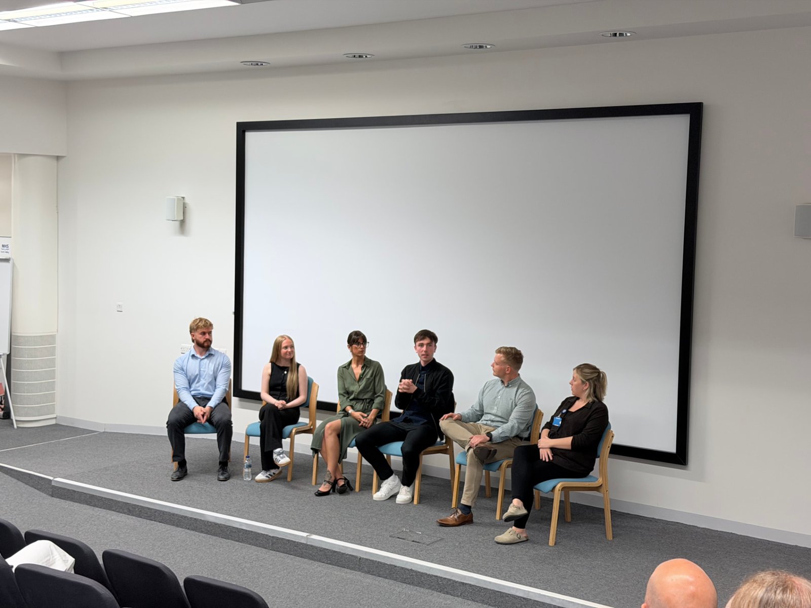 Students and NHS Forth Valley staff seated in a panel discussion on stage